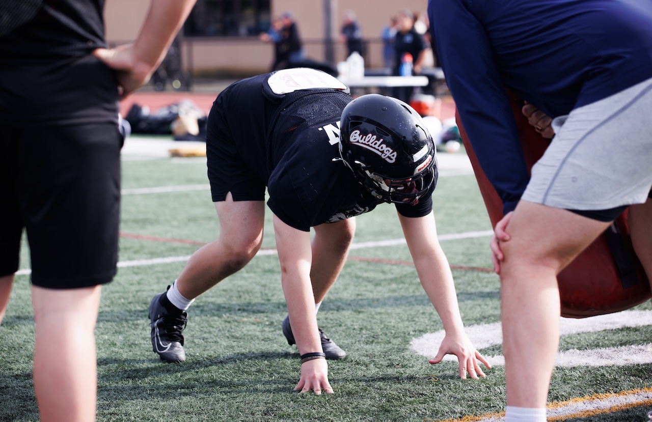 Defensive lineman in helmet and shoulder pads in his stance